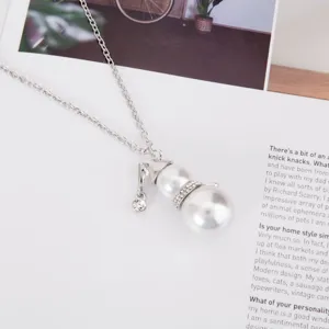 Close-up of a snowman pendant necklace with pearls and rhinestones for Christmas.