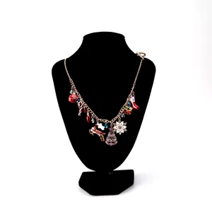 Festive Christmas charm necklace featuring snowflake, tree, and reindeer enamel pendants.
