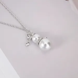 Detail macro view of cute snowman pearl pendant necklace with rhinestone accents