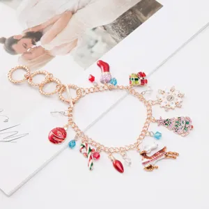 Close-up of a gold charm bracelet featuring colorful Christmas-themed pendants.