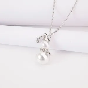 Close-up of cute snowman pendant necklace with white pearls and rhinestone scarf detail