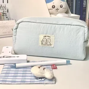 Close-up detail view of the cute light blue canvas pencil case featuring a sweet cat fabric label.