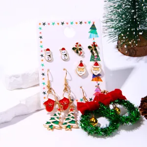 Detail view of a festive Christmas earring set with enamel charms on white card