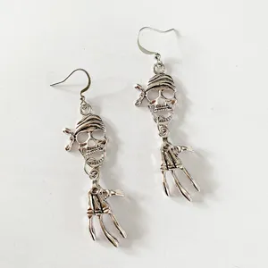 Detailweergave van vintage piraat schedel en skelet hand oorbellen voor Halloween.