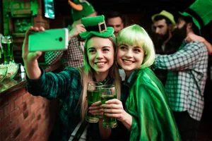 Vrolijke vrienden vieren St. Patrick's Day met groen bier en feestelijke kostuums in de pub