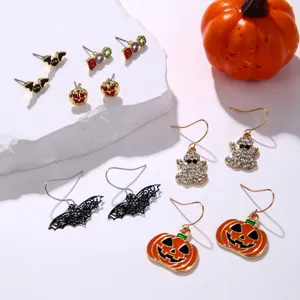 Close-up of a diverse Halloween earring set including pumpkin, ghost, and bat stud designs