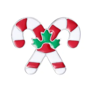 Kerst zuurstok emaille broche met groen blad detail op een witte achtergrond.