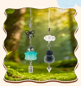 Détail de deux jolis charms chat avec perles décoratives et pendentifs en cœur