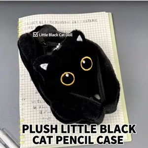 Detailed close-up of a plush black cat pencil case with yellow eyes on a notebook.