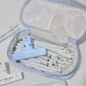 Dettaglio dell'interno dell'astuccio blu a pois con molti scomparti per penne