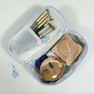 Vista interna dettagliata della borsa portaoggetti blu a pois per trucco e penne.