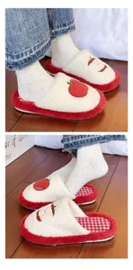 Cute red apple plush cotton slippers detail view, soft warm winter indoor floor shoes.