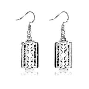 Close-up of vintage silver razor blade drop earrings featuring unique blade design.
