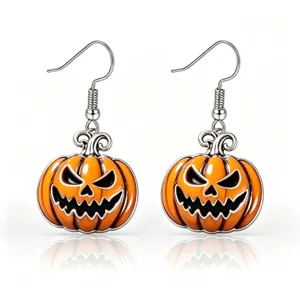 Detailed macro view of orange enamel Halloween pumpkin dangle earrings with silver hooks