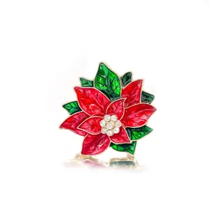 Close-up view of a festive Christmas Poinsettia brooch featuring red enamel and crystals