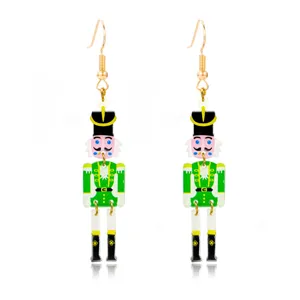 Detailed view of festive green nutcracker Christmas drop earrings with gold hooks.