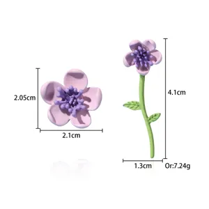 Detail view of mismatched floral earrings showing height and width measurements in cm