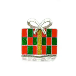 Detailed macro view of a Christmas gift box brooch with red green enamel and silver bow