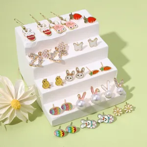 Close-up of colorful enamel Easter earrings set with rabbit and carrot designs