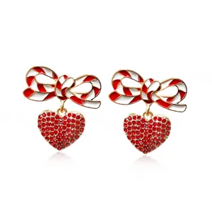 Close-up of Christmas bowknot earrings with red striped enamel and crystal heart
