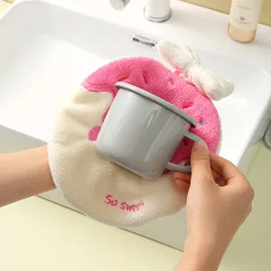 Close-up of a soft donut-shaped coral fleece hand towel with decorative bow and embroidery