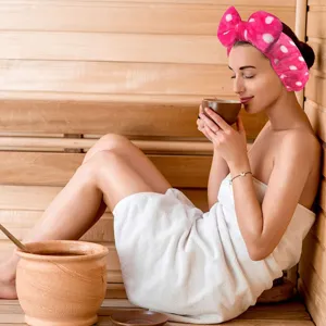 Detailed view of a soft flannel polka dot bow headband worn in a relaxing spa sauna room.
