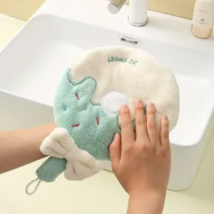 Absorbent coral fleece donut-shaped hanging hand towel for kitchen and bathroom usage.