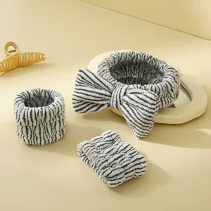 Ensemble bandeau de spa en peluche rayee noir et blanc et bracelet de lavage pour le visage.