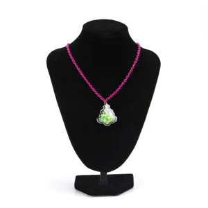 Vue détaillée d'un collier rose avec un pendentif sapin de Noël vert à paillettes