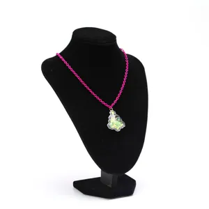 Détail du collier pendentif sapin de Noël avec une chaîne rose et des paillettes vertes.
