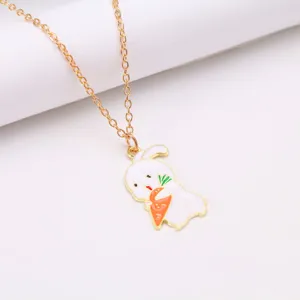 Close-up of a cute cartoon rabbit pendant holding a carrot on a gold chain necklace