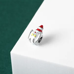 Detailed view of white enamel Christmas charm bead with red hat and yellow bow