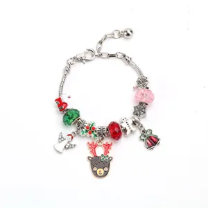 Primer plano de pulsera con dijes de Navidad con colgantes de reno y muñeco de nieve