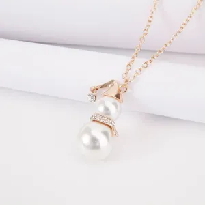 Detailed view of cute gold Christmas snowman pearl pendant necklace with sparkling rhinestones