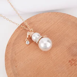 Close-up detail of a cute Christmas snowman pendant necklace with white pearls and sparkly crystals