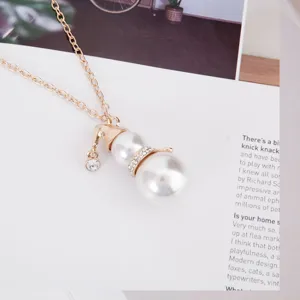 Close-up of cute snowman pendant necklace with white pearls and sparkling rhinestones