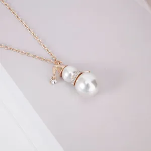 Close-up of a festive snowman pearl necklace with sparkling rhinestones and a gold hat