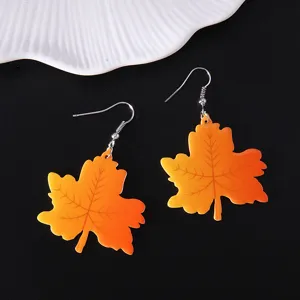Detailed view of vibrant orange gradient acrylic maple leaf dangle earrings for autumn.
