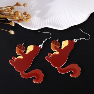 Detailed view of cute acrylic squirrel earrings holding an acorn for Thanksgiving