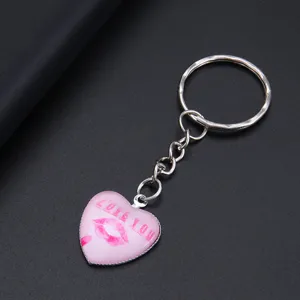 Detailopname van een roze hartvormige sleutelhanger met LOVE YOU-opdruk en rode lippen