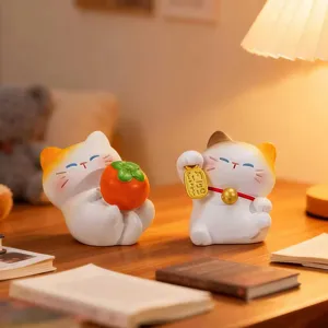 Süße Glückskatzen-Figuren für den Schreibtisch, eine Katze mit einer Kakifrucht