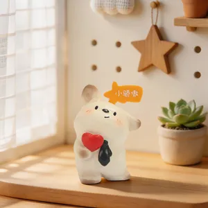 Close-up of a cute cartoon resin figurine holding a red heart with a speech bubble.