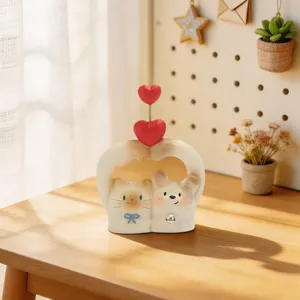 Cute cartoon resin cat and dog figurine with heart decoration on a warm wooden table