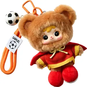 Lindo llavero de peluche con temática de fútbol, capucha de oso y una pequeña capa roja