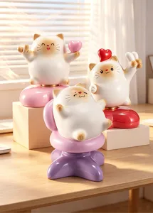 Détail de trois mignonnes figurines de chats de dessin animé en résine sur un bureau.