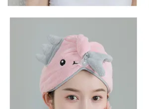 Close-up detail of the cute pink coral fleece dry hair cap with embroidered dinosaur horns.