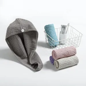 Detail shot of waffle coral velvet dry hair cap with button, shown in clean bathroom scene.