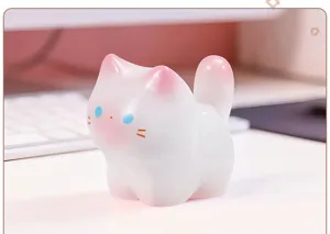 Gros plan d'une figurine de chat mignonne en résine blanche translucide aux oreilles roses