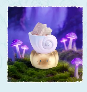 Gros plan de la figurine de chat énergie marine avec coquillage et cristal rose.