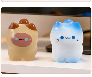 Gros plan de deux figurines de chat mignonnes en résine sur un bureau, styles marron et bleu